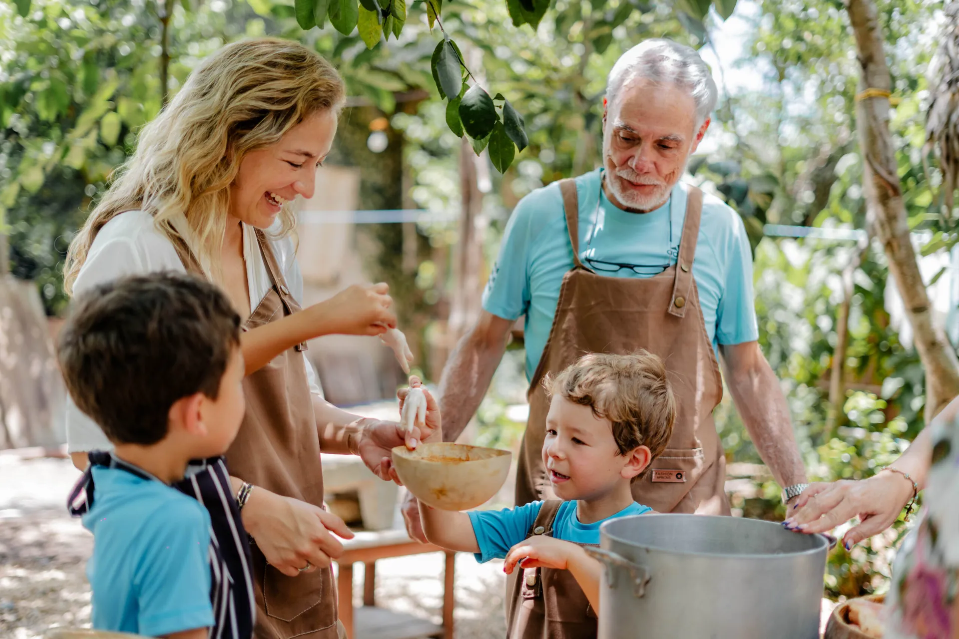 Family with two children enjoying a hands-on cooking class in a Mayan village in Yucatán, a small-group experience by Mexico Foodie Tours
